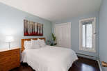 This inviting bedroom features a cozy ambiance with its soft blue walls and natural wood accents.