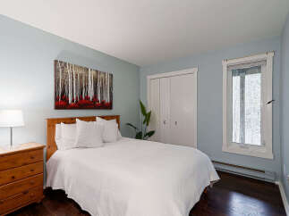 This inviting bedroom features a cozy ambiance with its soft blue walls and natural wood accents.