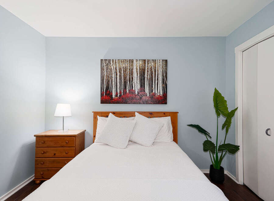 This cozy bedroom features a comfortable bed with crisp white linens and decorative pillows.