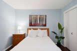 This cozy bedroom features a comfortable bed with crisp white linens and decorative pillows.