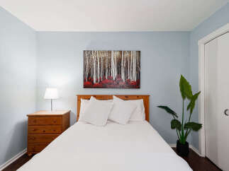 This cozy bedroom features a comfortable bed with crisp white linens and decorative pillows.