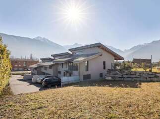 This stunning property boasts modern architecture with a neutral color palette, seamlessly blending with the surrounding natural beauty.
