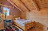 Discover the charm of this cozy bedroom, featuring a rustic wooden bed and a warm, inviting atmosphere.