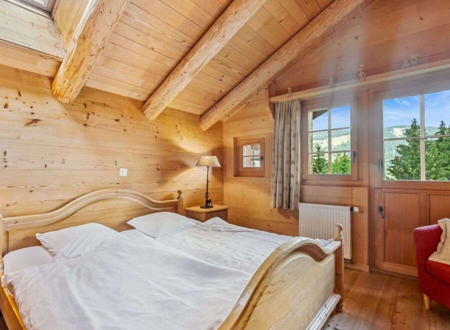 Experience the charm of this cozy bedroom, featuring a warm wooden interior and a comfortable bed.