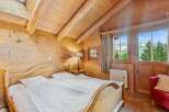 Experience the charm of this cozy bedroom, featuring a warm wooden interior and a comfortable bed.