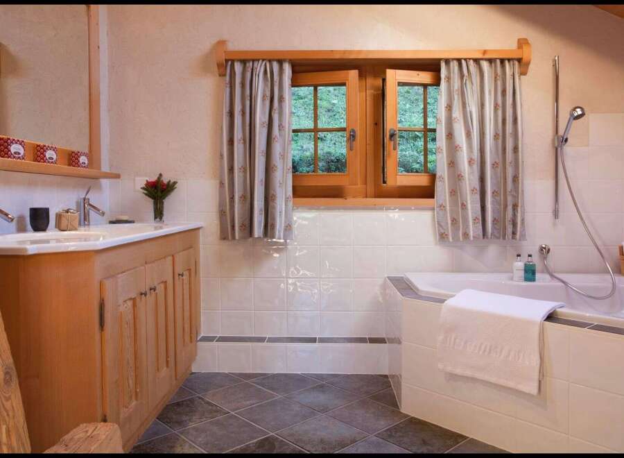 This charming bathroom features a rustic wooden vanity and a luxurious soaking tub, perfect for unwinding after a long day.