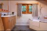 This charming bathroom features a rustic wooden vanity and a luxurious soaking tub, perfect for unwinding after a long day.