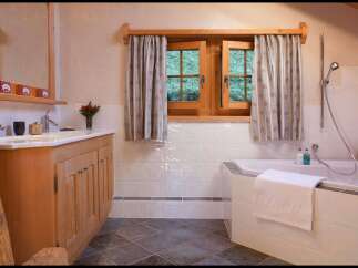 This charming bathroom features a rustic wooden vanity and a luxurious soaking tub, perfect for unwinding after a long day.