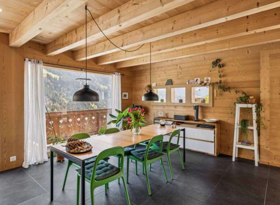 Experience the warmth of this stunning dining room, featuring a beautiful wooden ceiling and walls that create a cozy atmosphere.
