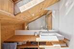 This stunning bathroom boasts a unique design with a sloped wooden ceiling, creating a cozy and inviting atmosphere.