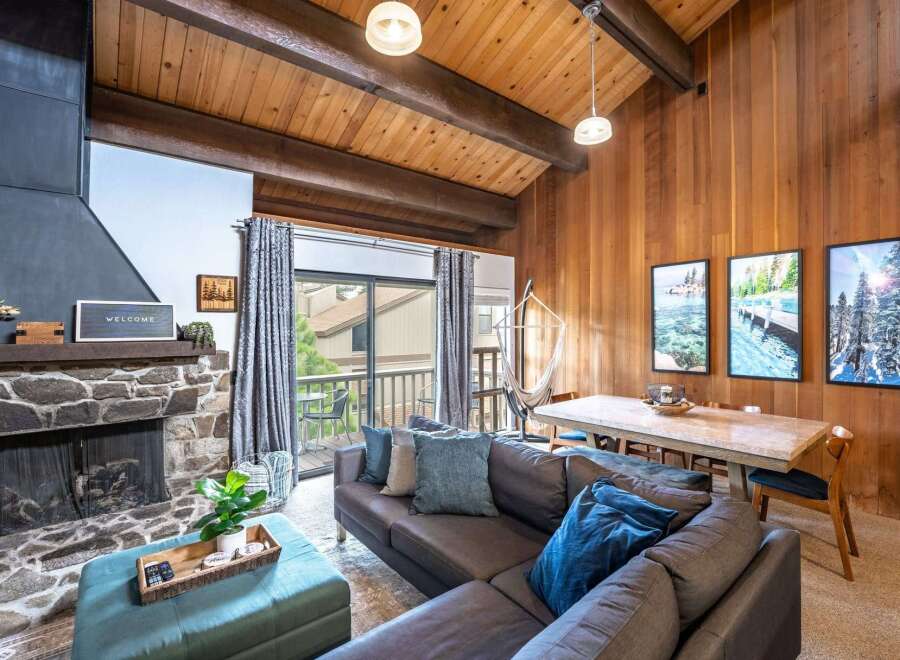 Step into this inviting living space, featuring a cozy stone fireplace and a stylish sectional sofa.