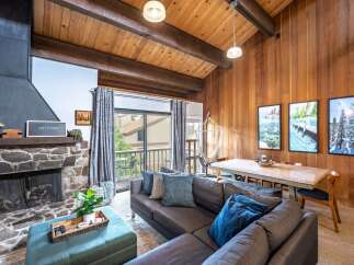 Step into this inviting living space, featuring a cozy stone fireplace and a stylish sectional sofa.