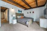 Step into this inviting bedroom featuring a stunning wooden ceiling and a cozy ambiance.