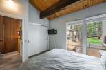 Discover the charm of this inviting bedroom, featuring a cozy bed and a mounted TV for entertainment.