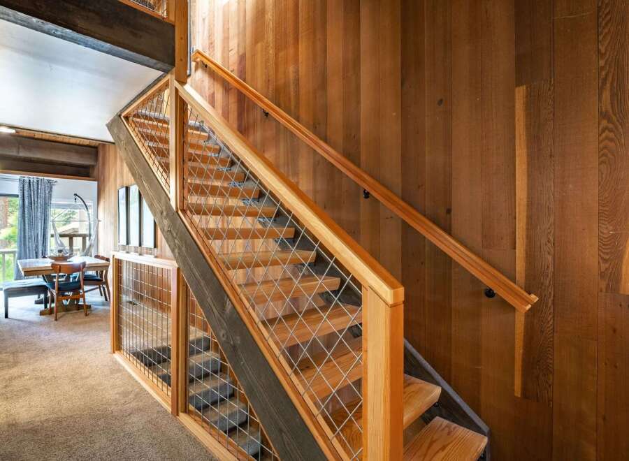 This stunning property boasts a beautifully crafted staircase with a modern design, featuring wooden steps and a sleek metal railing.