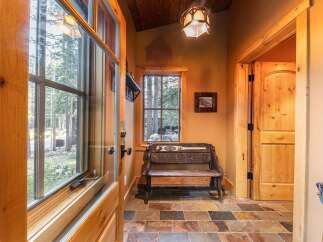 Step into this inviting entryway, showcasing a rustic bench and a welcoming 'Welcome' sign.