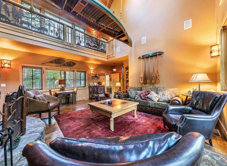 Step into rustic luxury with this stunning property, featuring a unique canoe suspended from the ceiling and a cozy fireplace.