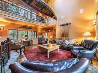 Step into rustic luxury with this stunning property, featuring a unique canoe suspended from the ceiling and a cozy fireplace.