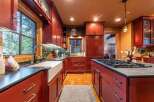 This stunning kitchen boasts rich, red cabinetry and a spacious layout, perfect for culinary enthusiasts.