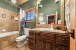 Step into this charming bathroom, featuring a rustic wooden vanity and a cozy ambiance.