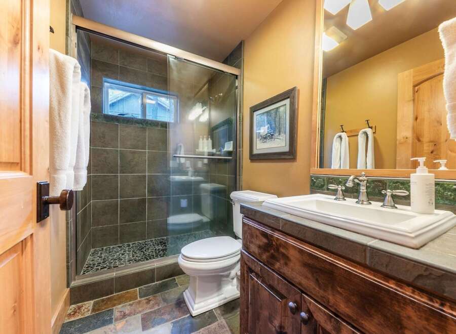 Step into this beautifully designed bathroom featuring a walk-in shower with a glass door and a stylish vanity.