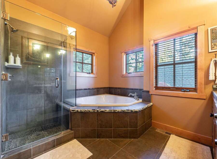 Step into luxury with this stunning bathroom featuring a corner bathtub and a separate glass-enclosed shower.