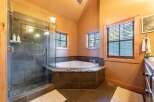 Step into luxury with this stunning bathroom featuring a corner bathtub and a separate glass-enclosed shower.