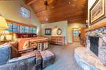 Experience rustic luxury in this stunning bedroom featuring a cozy fireplace and a king-sized bed.