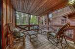 Enjoy the tranquility of this stunning cabin porch, perfect for relaxing and taking in the natural beauty.