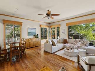 Step into luxury with this stunning property, featuring a spacious living area with a cozy sectional sofa and a beautiful view.