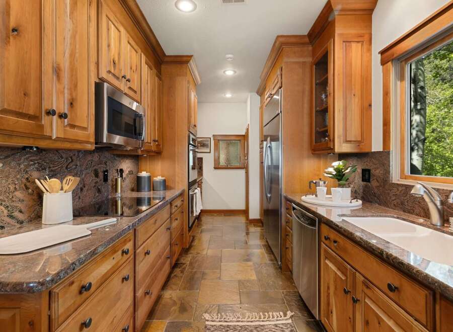 Step into this stunning kitchen, featuring custom wooden cabinetry and sleek stainless steel appliances.