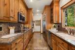 Step into this stunning kitchen, featuring custom wooden cabinetry and sleek stainless steel appliances.