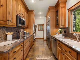 Step into this stunning kitchen, featuring custom wooden cabinetry and sleek stainless steel appliances.