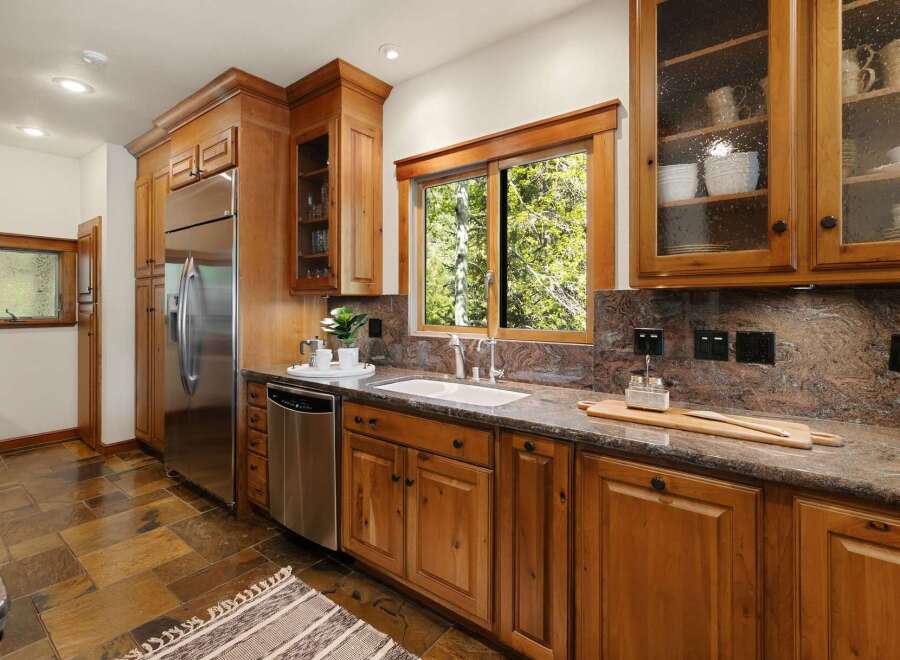 This stunning kitchen boasts custom wooden cabinetry, offering ample storage and a warm, inviting atmosphere.