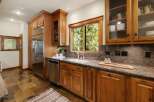This stunning kitchen boasts custom wooden cabinetry, offering ample storage and a warm, inviting atmosphere.