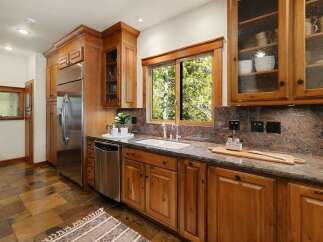 This stunning kitchen boasts custom wooden cabinetry, offering ample storage and a warm, inviting atmosphere.