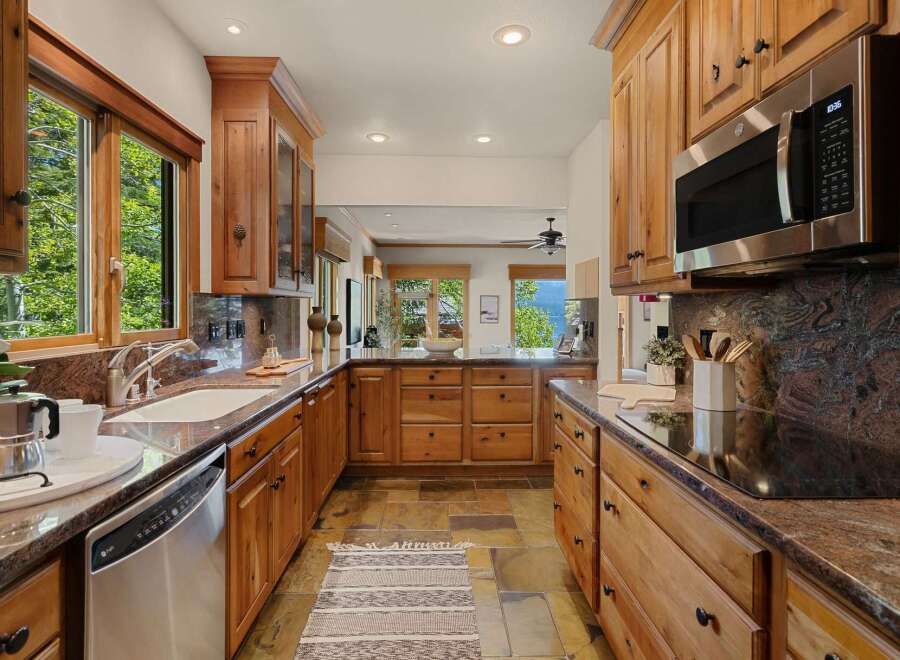 This stunning kitchen boasts custom wooden cabinetry, offering ample storage and a warm, inviting atmosphere.
