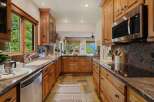 This stunning kitchen boasts custom wooden cabinetry, offering ample storage and a warm, inviting atmosphere.
