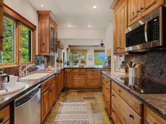 This stunning kitchen boasts custom wooden cabinetry, offering ample storage and a warm, inviting atmosphere.