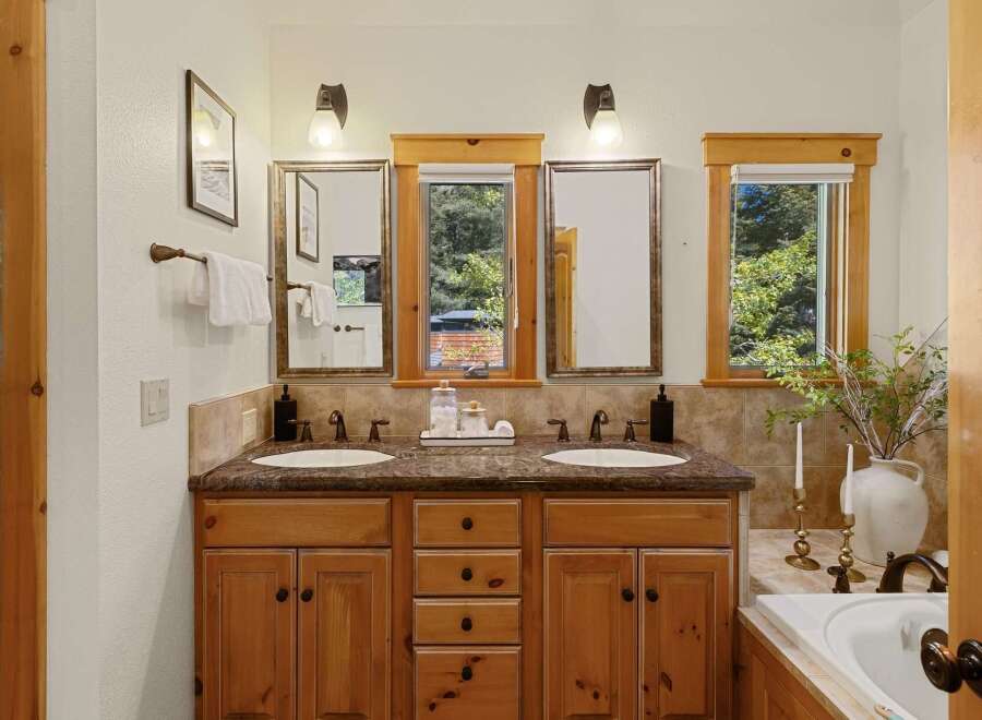 This stunning bathroom boasts a double vanity with a beautiful wood cabinet, offering ample storage and a touch of rustic elegance.