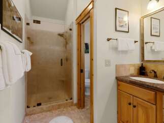 Step into a beautifully designed bathroom featuring a spacious glass shower and elegant wooden accents.