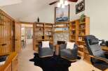 Step into luxury with this stunning property, featuring a cozy living room with a fireplace and built-in bookshelves.