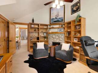 Step into luxury with this stunning property, featuring a cozy living room with a fireplace and built-in bookshelves.