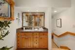 This stunning bathroom features a beautiful wooden vanity with ample storage and a granite countertop, offering both style and functionality.