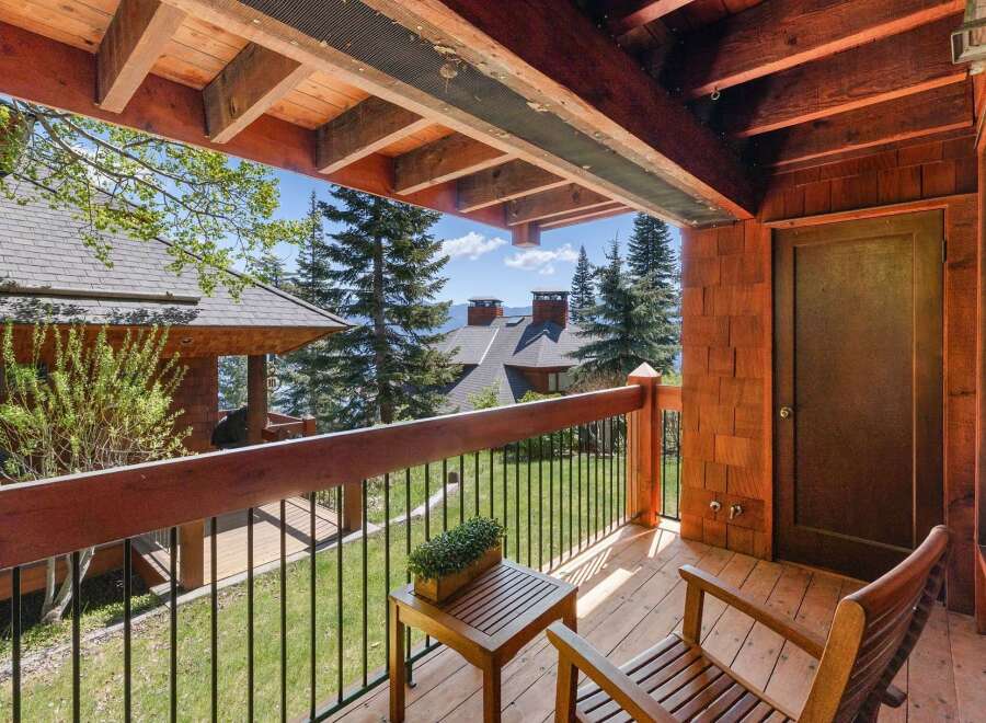 Enjoy breathtaking views from this stunning property, featuring a charming wooden deck and inviting outdoor seating.