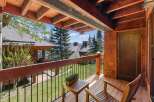 Enjoy breathtaking views from this stunning property, featuring a charming wooden deck and inviting outdoor seating.