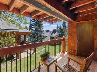 Enjoy breathtaking views from this stunning property, featuring a charming wooden deck and inviting outdoor seating.