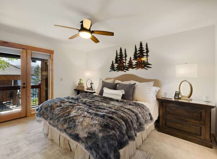This stunning bedroom boasts a cozy ambiance with its plush, faux fur blanket and inviting decor.