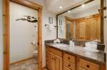 This stunning bathroom boasts a rustic charm with its wooden cabinetry and trim, creating a warm and inviting atmosphere.