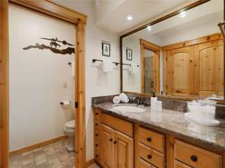 This stunning bathroom boasts a rustic charm with its wooden cabinetry and trim, creating a warm and inviting atmosphere.